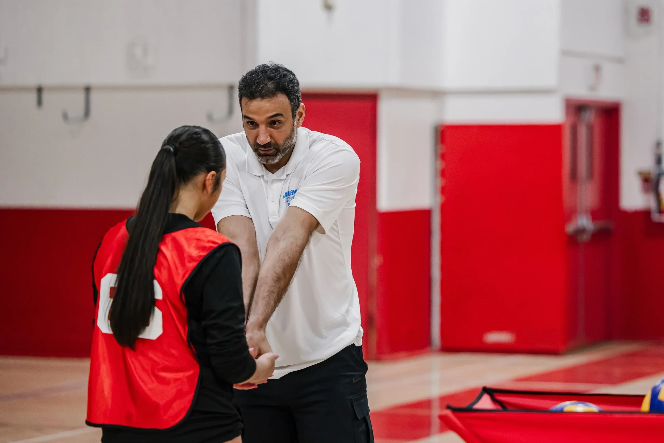 SDVA coach providing one-on-one youth volleyball training feedback